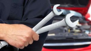 car mechanic holds spanners